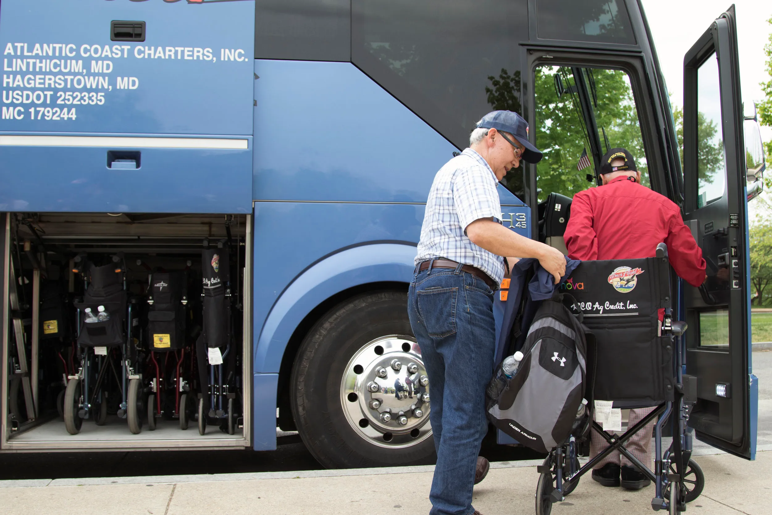 A volunteer helps a veteran with the Central Valley Honor Flight program return to the tour bus after viewing the National World War II Memorial in Washington, D.C., on April 26, 2016. Sixty-six veterans, 63 men and three women, from the central Sa